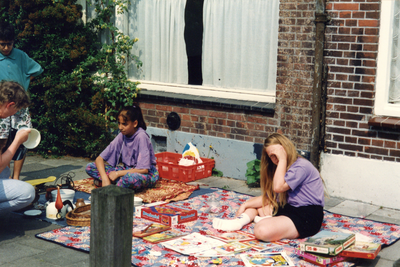 859404 Afbeelding enkele kinderen met een uitstalling van te verkopen spullen tijdens een buurtfeest met rommelmarkt op ...